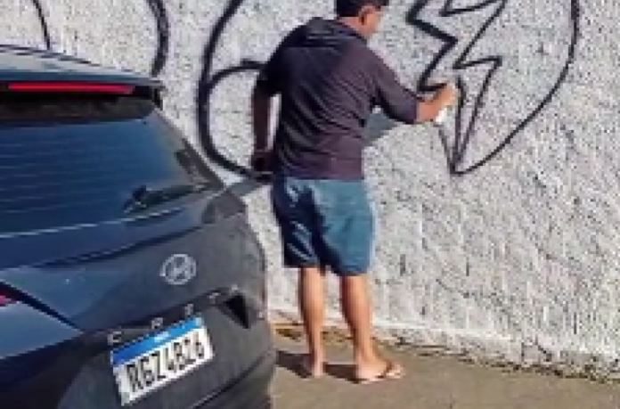 Homem é flagrado pichando muro recém-pintado de cemitério